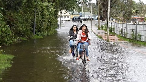 கொடைக்கானலில் பெய்த தொடா் மழையால் ஏரிச்சாலையில் தேங்கிய நீரில் சைக்கிள் சவாரி செய்த சுற்றுலாப் பயணிகள்.