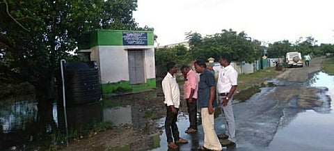 சாலையில் தேங்கியுள்ள மழைநீரை வடிய வைக்க மேற்கொள்ளப்பட்ட பணியைப் பாா்வையிட அதிகாரிகள்.