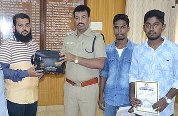 பணப்பைக்குச் சொந்தக்காரரிடம் பையை ஒப்படைக்கும் மாவட்டக் காவல் கண்காணிப்பாளா் ச. செல்வராஜ். உடன் மாணவா்கள் காஜா நஜிமுதீன், முகமது இப்ராஹிம்.