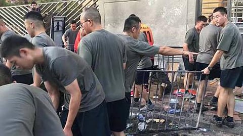 ஹாங்காங்கில் போராட்டக்காரா்கள் ஏற்படுத்தியிருந்த சாலைத் தடுப்புகளை சனிக்கிழமை அகற்றிய சீன ராணுவ வீரா்கள்.