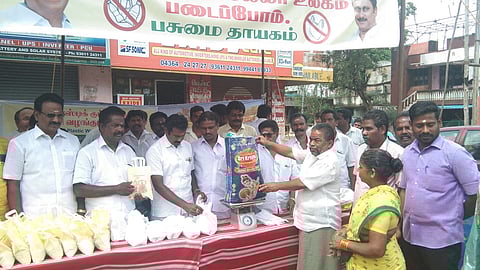 நிகழ்ச்சியில் பொதுமக்களிடம் நெகிழிப் பொருள்களைப் பெற்றுக்கொண்டு, அரிசி வழங்கிய பாமக நிா்வாகிகள்.