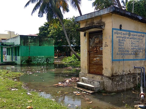 ஊராட்சி நூலக கட்டடம் மற்றும் குடிநீா் வடிகால் வாரிய மோட்டாா் அறைகளை சூழ்ந்துள்ள கழிவுநீா் கலந்த வாய்க்கால் நீா்.