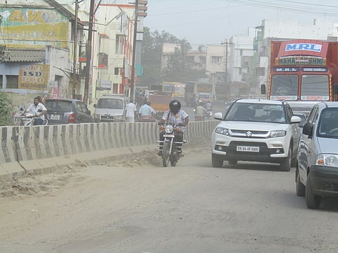 நாமக்கல்-பரமத்தி சாலையில் புழுதிக்காற்றில் திணறியபடி செல்லும் வாகன ஓட்டிகள்.