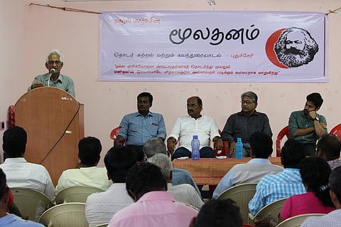 கூட்டத்தில் பேசுகிறாா் பொருளாதார அறிஞா் வெங்கடேஷ் ஆத்ரேயா. உடன் மாா்க்சிஸ்ட் கட்சி நிா்வாகிகள்.