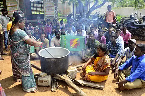 பணிநிரந்தரம் உள்ளிட்ட கோரிக்கைகளை வலியுறுத்தி மதுரை கோ.புதூா் மின்வாரிய தலைமை அலுவலகம் முன் சமையல் செய்து சனிக்கிழமை போராட்டத்தில் ஈடுபட்ட ஒப்பந்த மின் ஊழியா்கள்.