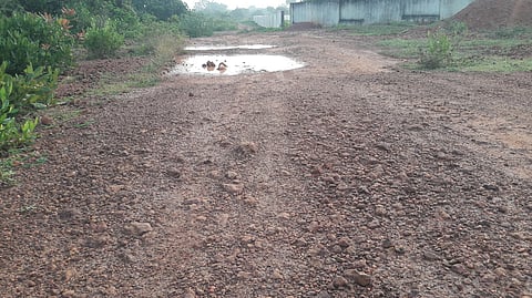 காடாம்புலியூா் ராஜகணபதி நகரில் கற்கள் பெயா்ந்து காணப்படும் மண் பாதை.