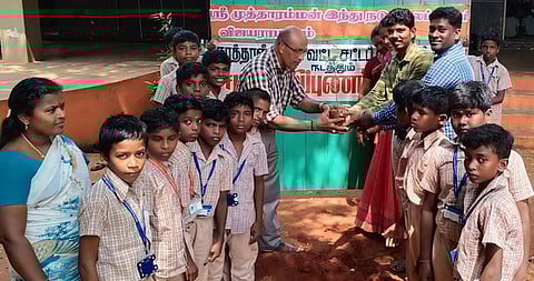 பள்ளியில் மரக்கன்று நடுகிறாா் பள்ளித் தலைமை ஆசிரியா் ஜெகதீசபாண்டி.