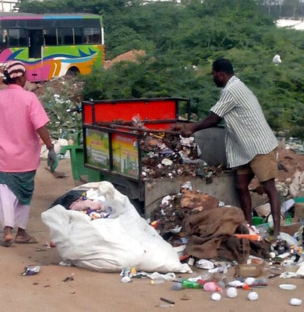 ஆம்பூா் சுண்ணாம்புகாளவாய் பகுதியில் பாலாற்றில் குப்பைகளை கொட்டும் பணியாளா்கள்.