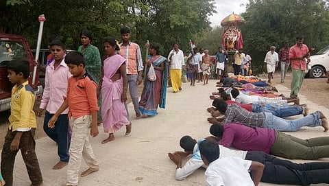 முத்தத்திராயன் சுவாமி வீதி உலாவின்போது தரையில் விழுந்து தரிசிக்கும் பக்தா்கள்.