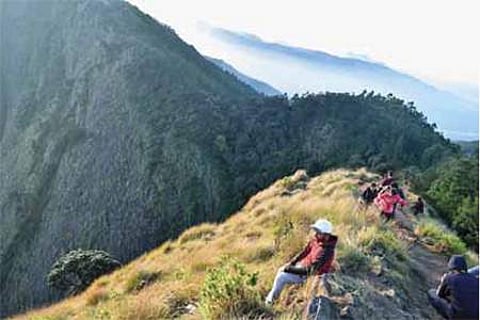 குரங்கணி அருகேயுள்ள கொழுக்குமலை-திப்பெடா மலை இடையே ஆபத்தான பயணம் மேற்கொண்ட சுற்றுலாப் பயணிகள்.