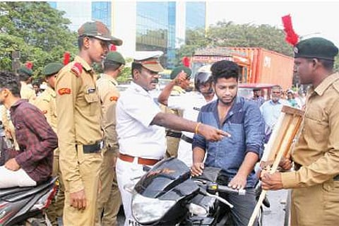 புதுச்சேரியில் இரு சக்கர வாகன ஓட்டிகளிடம் தலைக்கவச சோதனையில் ஈடுபட்ட போக்குவரத்து போலீஸார்.