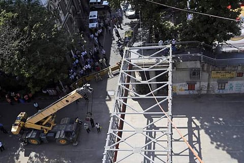 விபத்துக்குள்ளான இரும்பு மேம்பாலத்தை அகற்றும் பணியில் வெள்ளிக்கிழமை ஈடுபட்ட மீட்புப் பணியினர்.