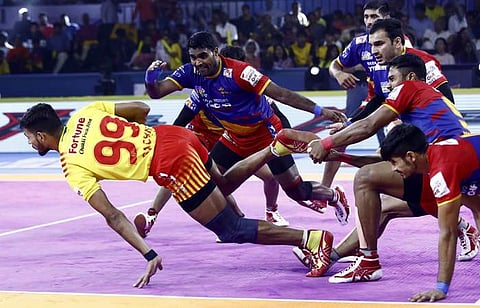 யு.பி. யோதா அணி வீரர்கள் பிடியிலிருந்து தப்பும் குஜராத் வீரர்.