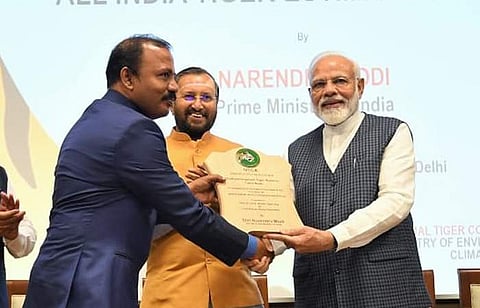 புலிகள் பாதுகாப்பில் சிறந்த மேலாண்மைக்கான விருதை பிரதமர் நரேந்திர மோடியிடம் இருந்து பெறும் சத்தியமங்கலம் புலிகள் காப்பக மண்டல காப்பாளர் நாகநாதன். உடன், மத்திய வனத் துறை அமைச்சர்