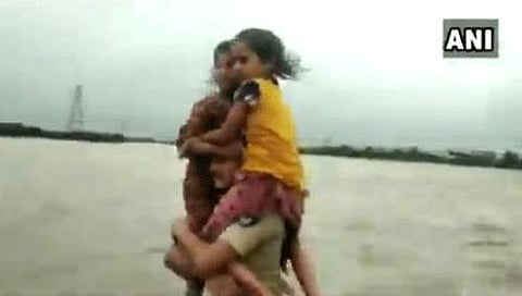 குஜராத் வெள்ளத்தில் சிக்கிய சிறுமிகள் மீட்பு: தோளில் சுமந்து சென்ற காவலருக்கு குவியும் பாராட்டு!