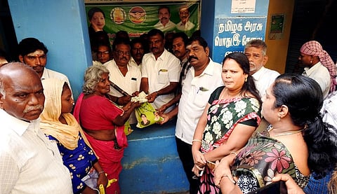 அன்னூா் கூட்டுறவு பண்டக சாலையில் பொங்கல் பொருள்களை பயனாளிகளுக்கு வழங்குகிறாா் துணைத் தலைவா் தாளத்துரை செந்தில்.