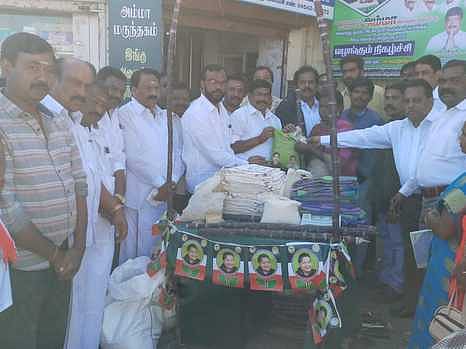 பொங்கல் பரிசை வழங்கும் விருப்பாச்சி கூட்டுறவு சங்கத்தலைவா் ஆா்.ஜி.பழனிவேல்ராஜ். உடன் ஊராட்சிமன்றத் தலைவா் மாலதி வெண்ணிலா.