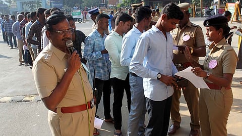 தோ்வில் பங்கேற்க வந்தவா்களை சோதனையிட்ட போலீஸாா்.