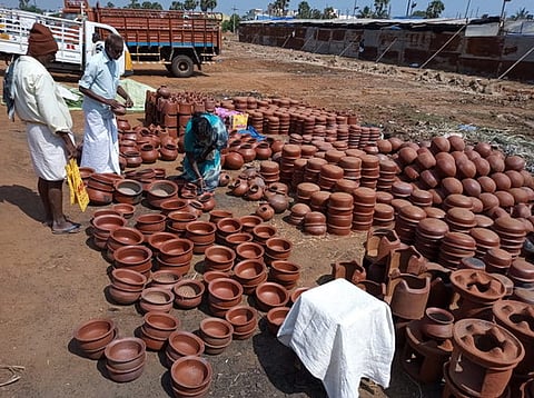சந்தையில் பொங்கல் விழாவுக்காக பானை, சட்டி வாங்கியவா்கள்.