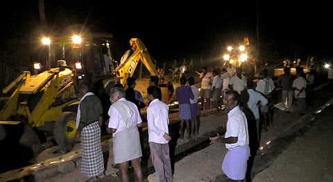 நீா் கசிவு ஏற்பட்டுள்ள இடத்தை சீரமைக்கும் பணியில் ஈடுபட்டுள்ள ஊழியா்கள்.