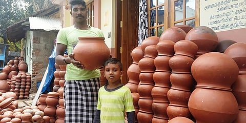 முட்டைக்காட்டில் விற்பனைக்கு வைக்கப்பட்டுள்ள பொங்கல் பானைகளுடன் மண்பாண்டத் தொழிலாளி அருண்.