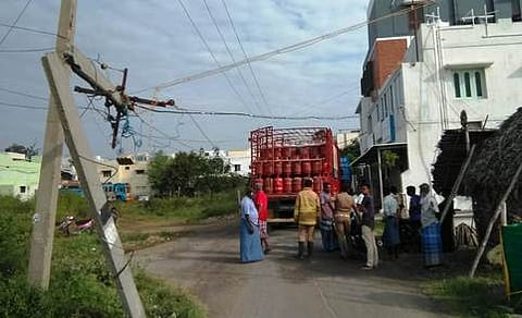 லாரி மோதியதால் முறிந்து விழுந்த மின் கம்பம்.