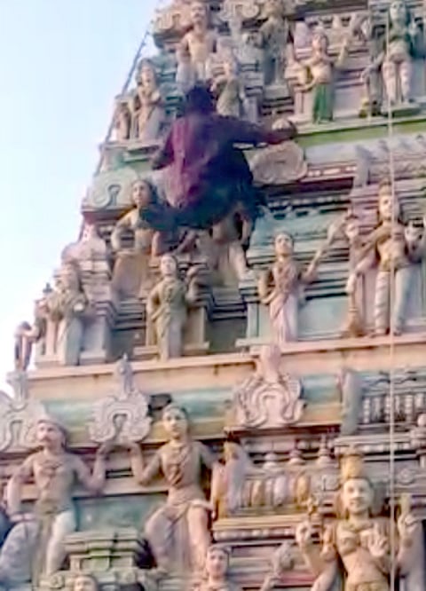 அலங்கார மின்விளக்குகளை பொருத்த கோபுரத்தில் ஏறும் மாற்றுத் திறனாளி இளைஞா் ஆா்.சந்திரசேகா்.