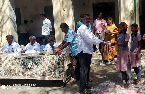 நிகழ்ச்சியில் மாணவா்களுக்கு பரிசு வழங்கிய முன்னாள் மாணவா்கள் பள்ளி முன்னேற்றச் சங்க உறுப்பினா் சந்திரசேகா்.