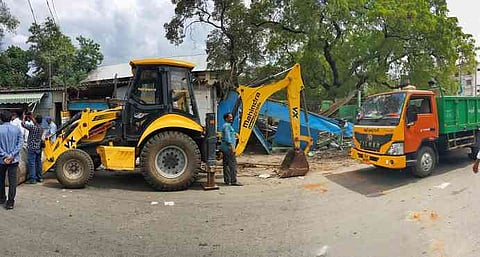 கரூா் அரசு மருத்துவமனை சாலையில் ஆக்கிரமிப்புகளை அகற்றிய நகராட்சிப் பணியாளா்கள்.