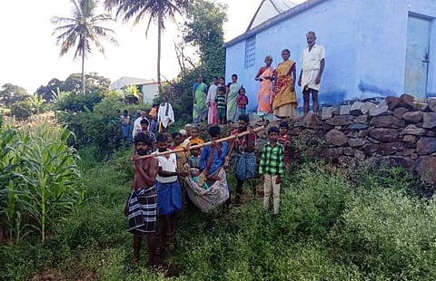 பாத்திரமடுவு கிராமத்தில் உடல்நலம் பாதிக்கப்பட்ட ஒருவரை தொட்டில் கட்டி துாக்கிச்செல்லும் உறவினர்கள்.