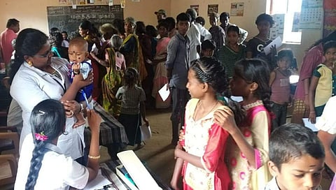 கொங்காடை மலை கிராமத்தில் நடைபெற்ற முகாமில் மலை கிராம குழந்தையை கொஞ்சி மகிழ்ந்த செவிலியர்கள்.