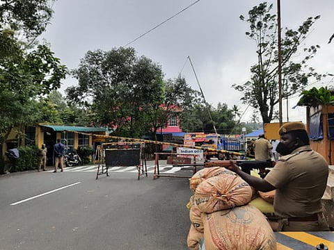 தமிழக-கேரள எல்லையான கம்பம்மெட்டில் மணல் மூட்டைகளில் அரண் அமைத்து பாதுகாப்பு பணியில் ஈடுபட்டுள்ள துப்பாக்கி ஏந்திய போலீஸாா்.