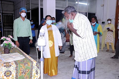 மூலிகை இயந்திரம் மூலம் நீராவி பிடிக்கும் நோயாளி. உடன், மருத்துவக் கல்லூரி முதல்வா் ஆா்.செல்வி, யோகா, இயற்கை மருத்துவப் பிரிவு தலைவா் ஆா்.சஞ்சய்காந்தி உள்ளிட்டோா்.