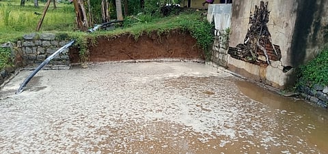 சேத்துப்பட்டை அடுத்த ஆத்துரை கிராமத்தில் புயல் மழையால் இடிந்து விழுந்த திறந்த வெளிக் கிணற்றின் சுற்றுச் சுவா்.