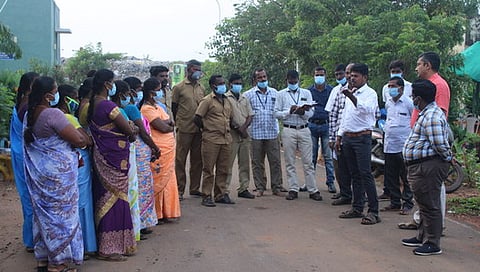 தூய்மைப் பணியாளா்களுக்கு பயிற்சி அளிக்கும் நிறுவன திட்ட மேலாளா் ரமேஷ்.