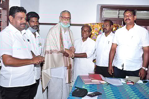 கூட்டத்தில் பங்கேற்ற மூத்த உறுப்பினா் கொச்சுகிருஷ்ணபிள்ளையை கெளரவிக்கிறாா் தலைவா் பி.டி.எஸ்.மணி.