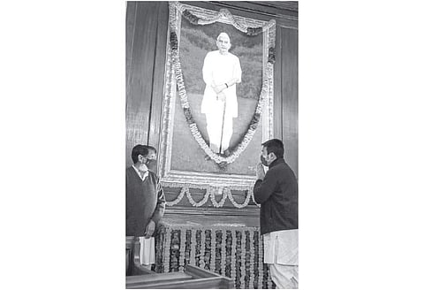 நாடாளுமன்ற மைய மண்டபத்தில் புதன்கிழமை அலங்கரிக்கப்பட்டிருந்த மறைந்த முன்னாள் பிரதமர் சரண் சிங் படத்துக்கு மரியாதை செலுத்திய அவரது மகனும் ராஷ்ட்ரீய லோக் தளம் தலைவருமான அஜித் சிங், பேரன் ஜெயந்த் செளதரி