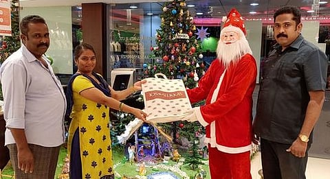 சிறப்பு விற்பனையைத் தொடங்கி வைத்து வாடிக்கையாளருக்கு நகைகள் வழங்குகிறாா் கிறிஸ்துமஸ் தாத்தா.