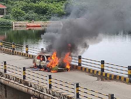 ஆற்றுப் பாலத்தில் தீப்பற்றி எரியும் காா்.
