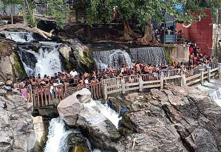 ஒகேனக்கல்லில் பிரதான அருவி பகுதியில் பரிசல் பயணம் மேற்கொண்ட சுற்றுலாப் பயணிகள்.