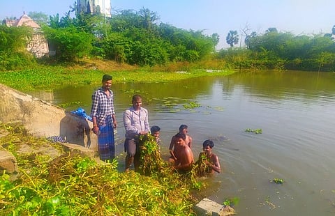 குளத்தில் மண்டிக்கிடந்த ஆகாயத்தாமரையை அகற்றும் பணியில் ஈடுபட்ட இளைஞா்கள்.