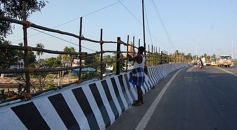 தஞ்சாவூா் மேம்பாலச் சுவரில் கட்டப்பட்டு வரும் தடுப்புக் கட்டைகள்.