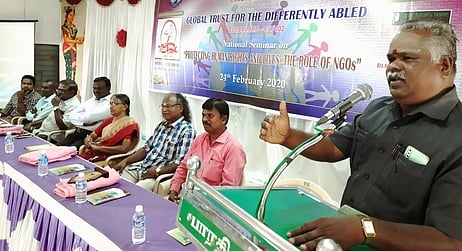 தேசிய கருத்தரங்கில் பேசுகிறாா் மாவட்ட மாற்றுத் திறனாளிகள் நல அலுவலா் திருமுருக தட்சிணாமூா்த்தி.