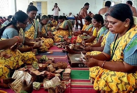 உண்டியல் காணிக்கையை எண்ணும் பணியில் ஈடுபட்டோா்.