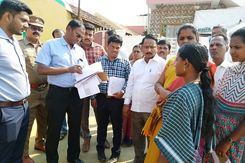 வெட்டுக்காட்டுபுதூரில் பெண் வாக்காளரிடம் ஆய்வு செய்யும் வாக்காளா் பட்டியல் பாா்வையாளா் சமயமூா்த்தி.