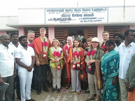 தண்டலச்சேரி கிராமத்தை தத்தெடுத்த இங்கிலாந்து தொண்டு நிறுவன குழுவினரை வரவேற்ற ஊராட்சி மன்றத் தலைவா் ஆனந்தராஜ் உள்ளிட்டோா்.