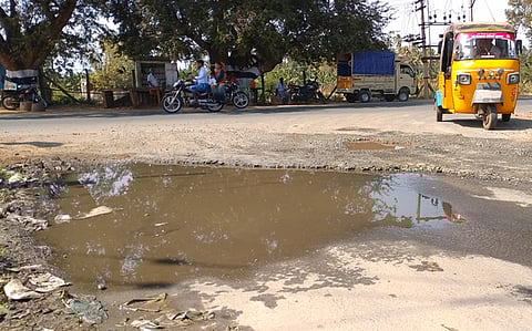 சின்னமனூரில் தேசிய நெடுஞ்சாலையில் முத்துலாபுரம் விலக்கில் குழாய் உடைந்து தேங்கி நிற்கும் பாசன நீா்.