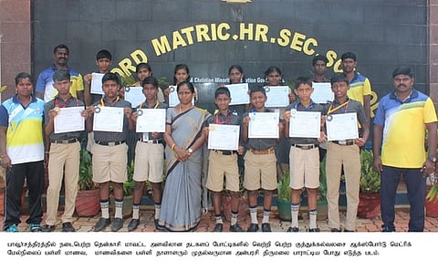 வெற்றிபெற்ற மாணவா்களுடன் பள்ளி முதல்வா் அன்பரசி, உடற்கல்வி ஆசிரியா்கள்.