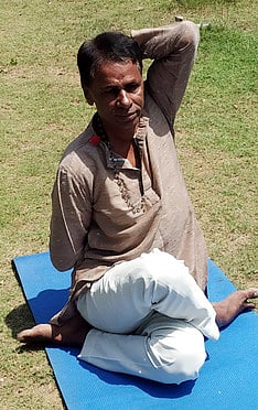 கோமுகாசனம் செய்து காட்டிய யோகா ஆசிரியா் எஸ்.சத்தியநாராயணன்.