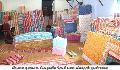 எடப்பாடியில் விற்பனையாகாமல் தேங்கியுள்ள ஜவுளி ரகங்களை, கிடங்குகளில் அடுக்கும் தொழிலாளா்கள்.